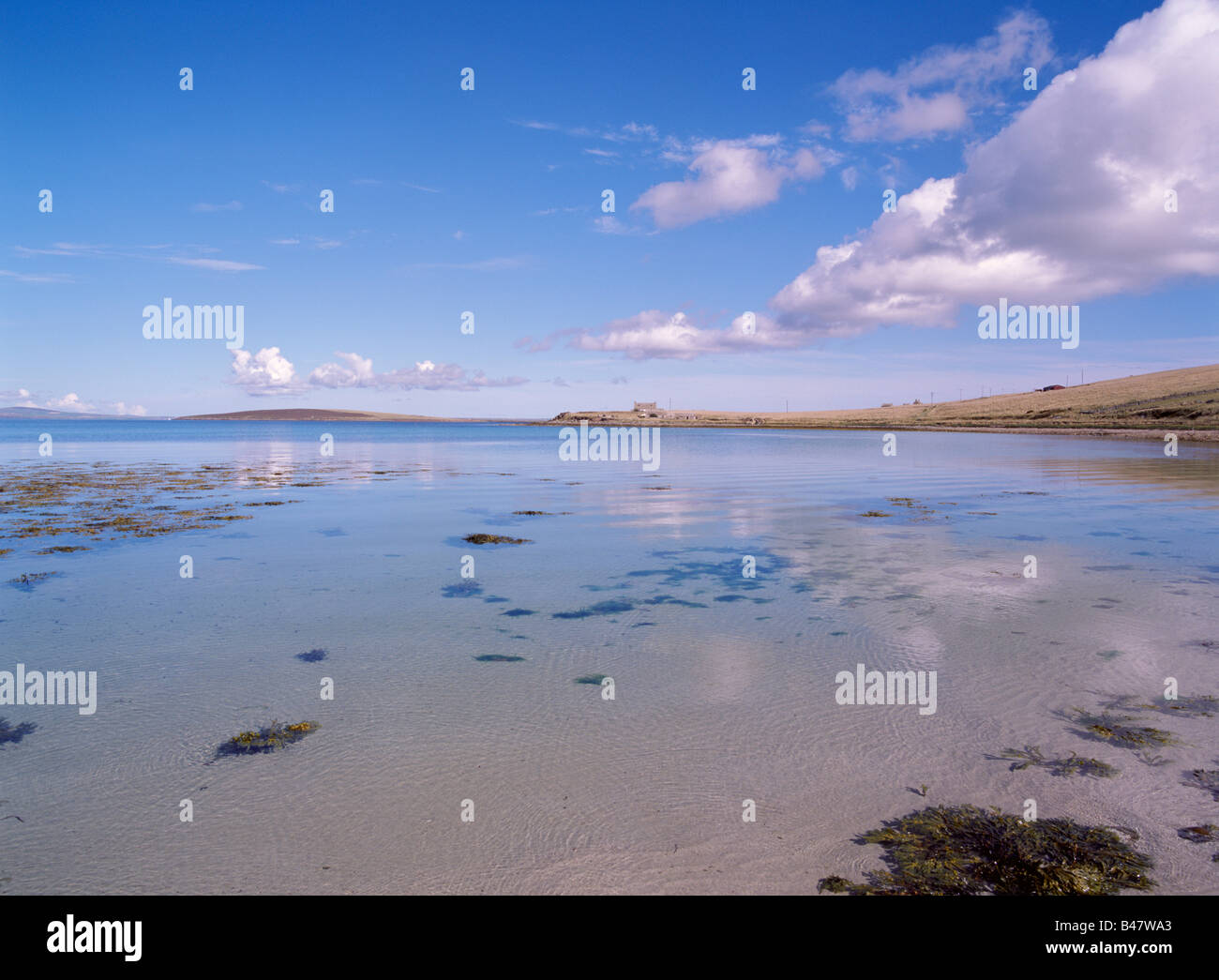 dh Hoxa SOUTH RONALDSAY ORKNEY Dam of Hoxa tranquil beach and cottage headland sandy sea shore coast blue Stock Photo