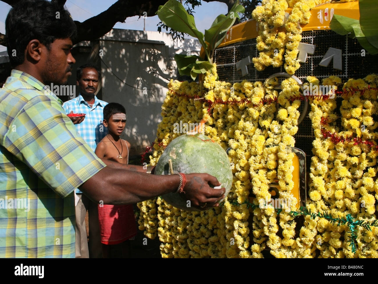 Man blesses his truck with a pumpkin and arti pooja , Vishwakarma Ayudha Puja ceremony , India Stock Photo