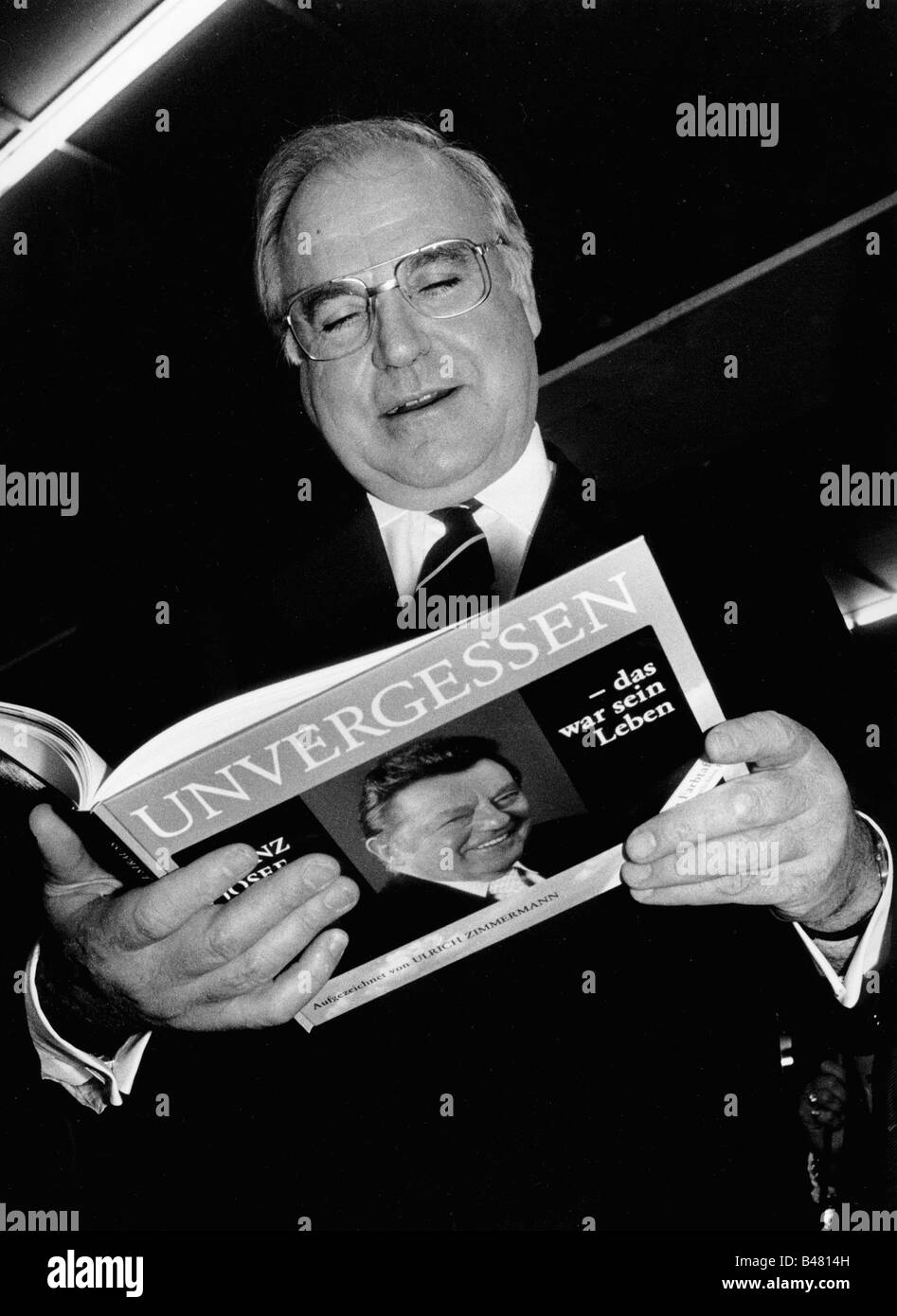 Kohl, Helmut, * 3.4.1930, German politician (CDU), chancellor of Germany 1982 - 1998, half length, with memorial book of pictures about Franz Josef Strauss 'Unvergessen' (Unforgotten) by Ulrich Zimmermann, party conference of CSU, Munich, 19.11.1988, Stock Photo