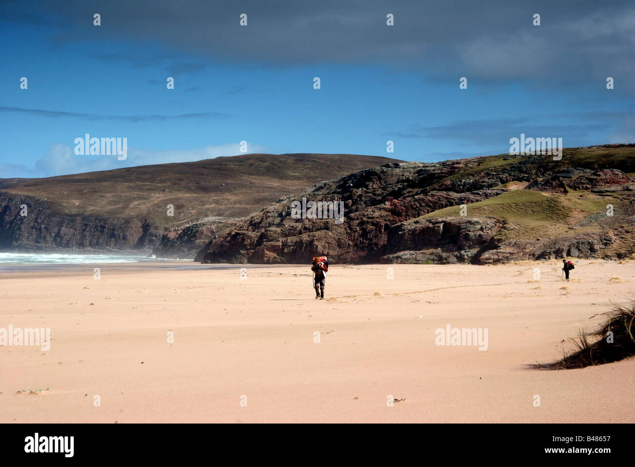 Hikers crossing Sandwood Bay on the Cape Wrath Trail Stock Photo