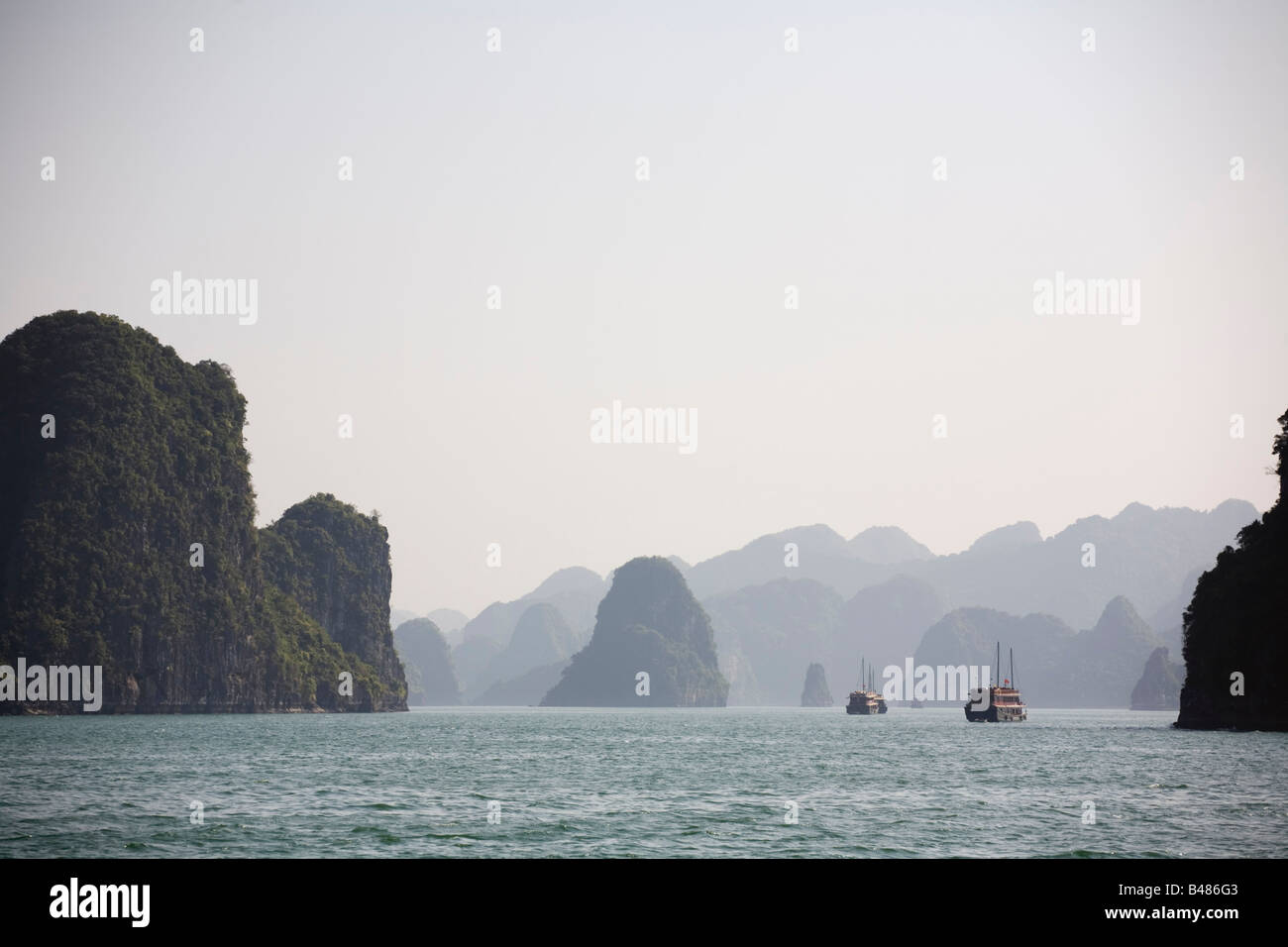 Junks and limestone karsts on the waters of Halong Bay Vietnam Stock Photo