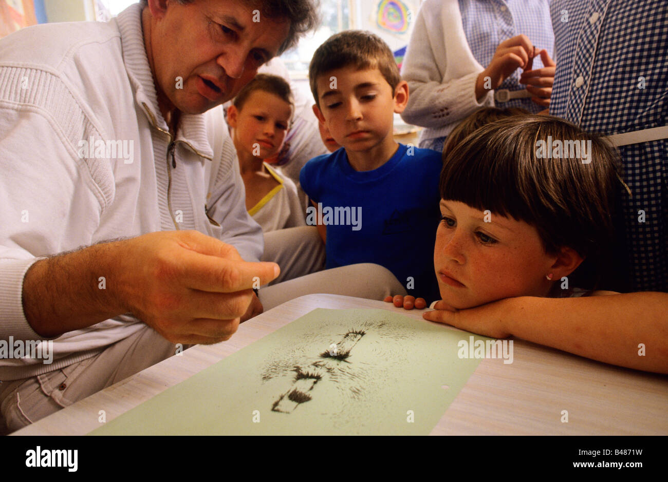 Primary school teacher explaining the priciples of magnetism to his class Stock Photo