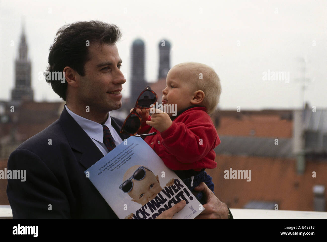 Travolta, John, * 18.2.1954, American actor, at press conference, movie premiere 'Look Who's Talking',  with baby 'Mikey', Hotel Raffael, Munich, 1990, Stock Photo