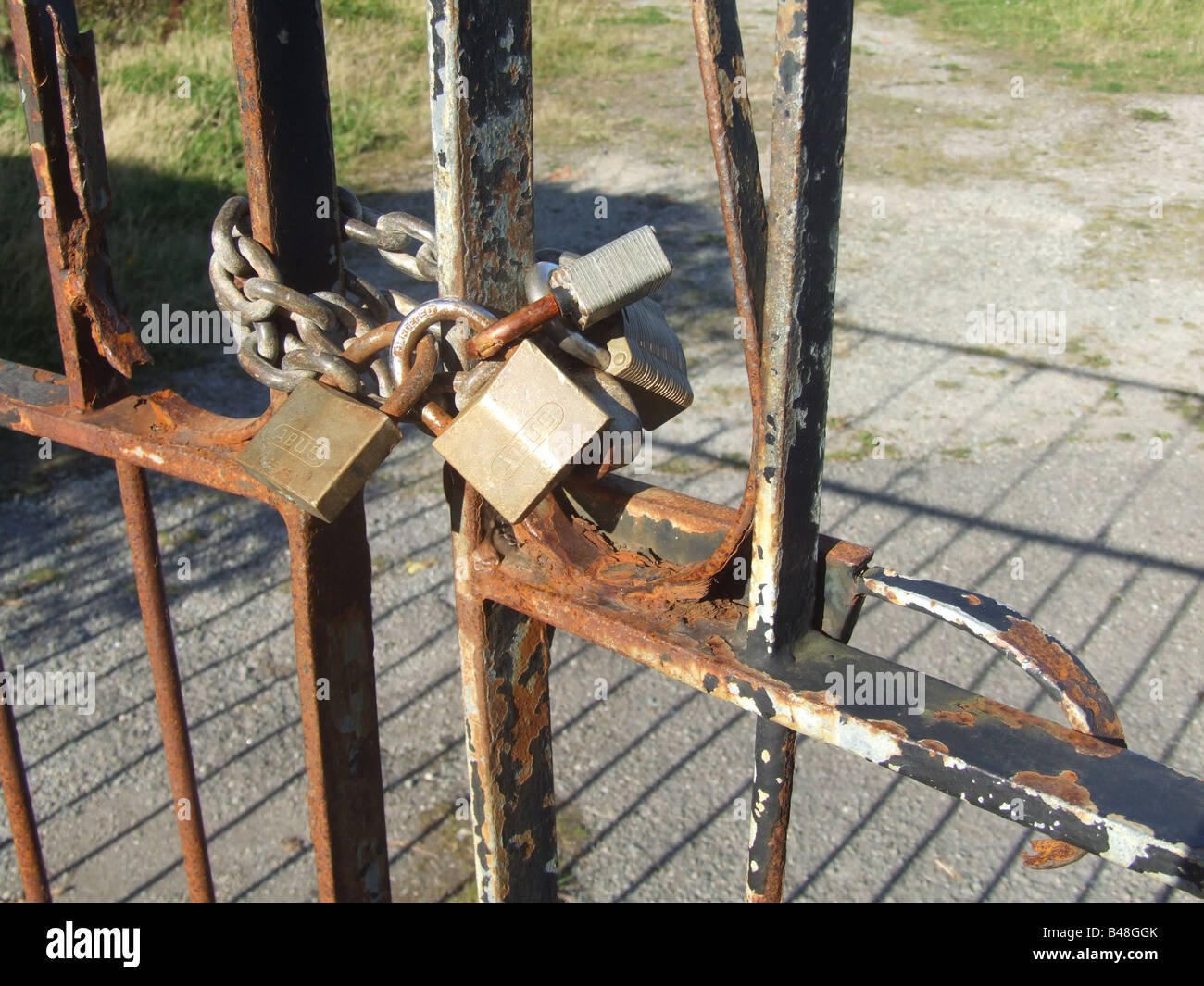 Rusty Lock Gate three pad locks old rusty gate by private property Stock Photo - Alamy