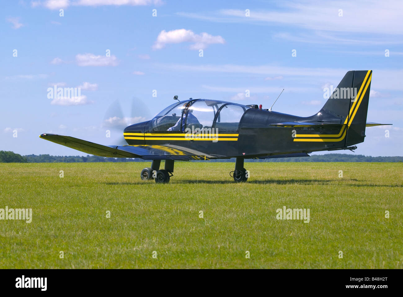 Single propeller light aircraft on a grass runway waiting for clearence to take off Stock Photo
