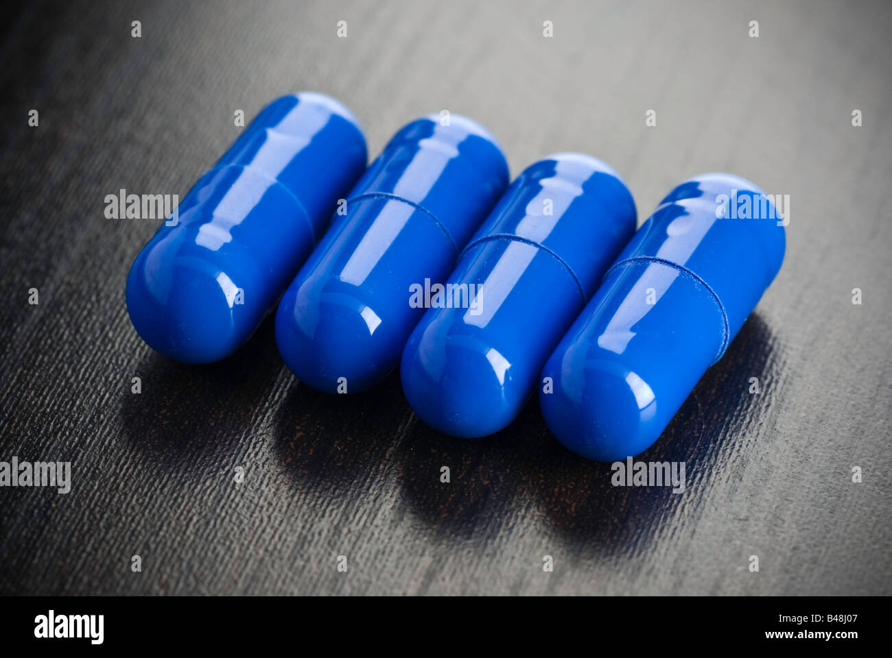 Some blue mediction on a black surface Stock Photo - Alamy