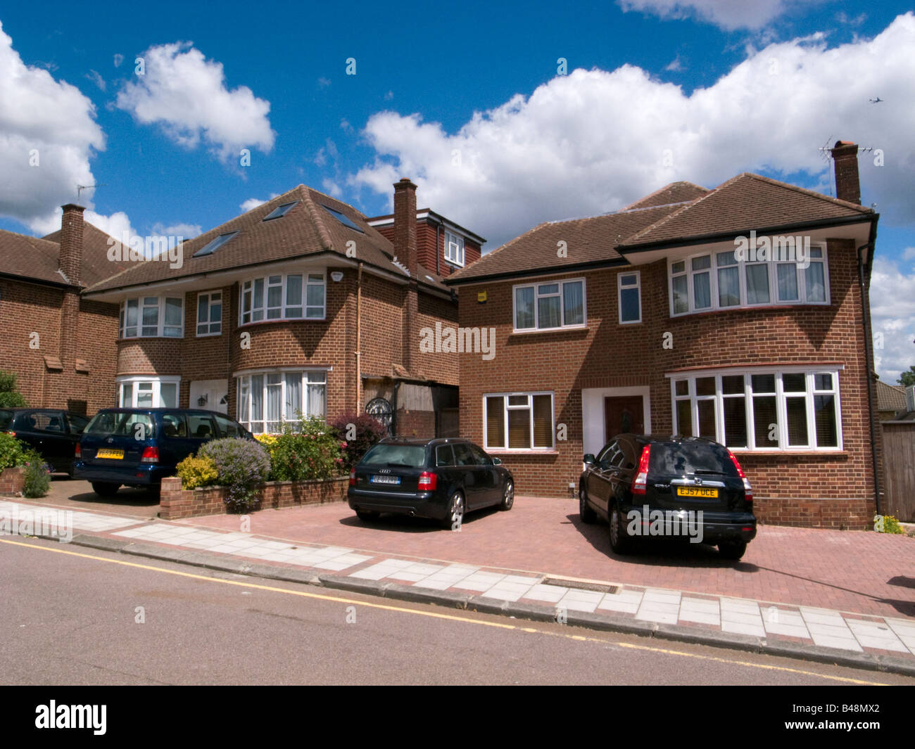 Cars parked on paved front gardens of houses, London England UK Stock Photo