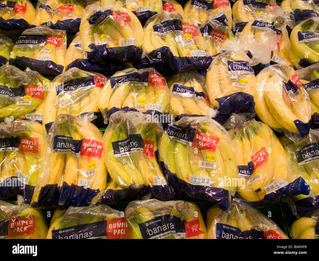 Bananas in clear plastic packaging at Morrisons supermarket, England,UK Stock Photo