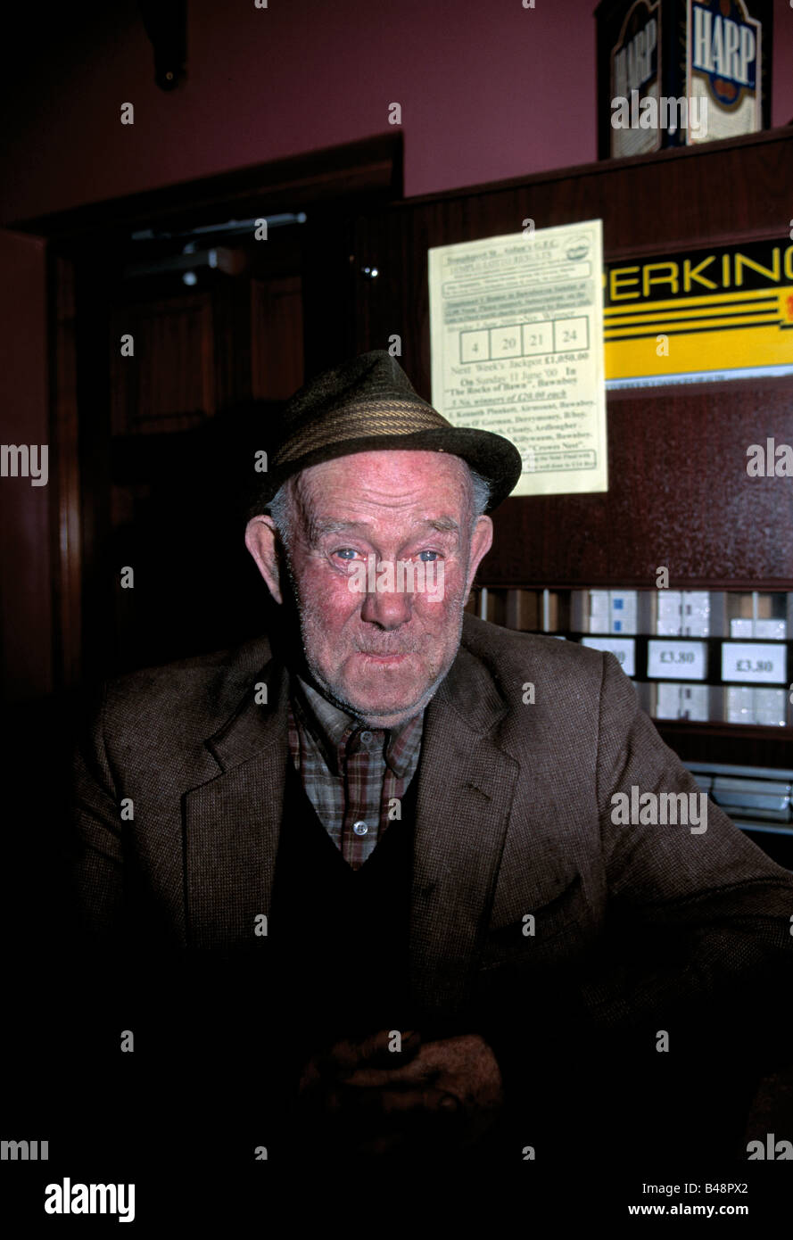 irish rural character, old irish man sitting in bar pub on his own with