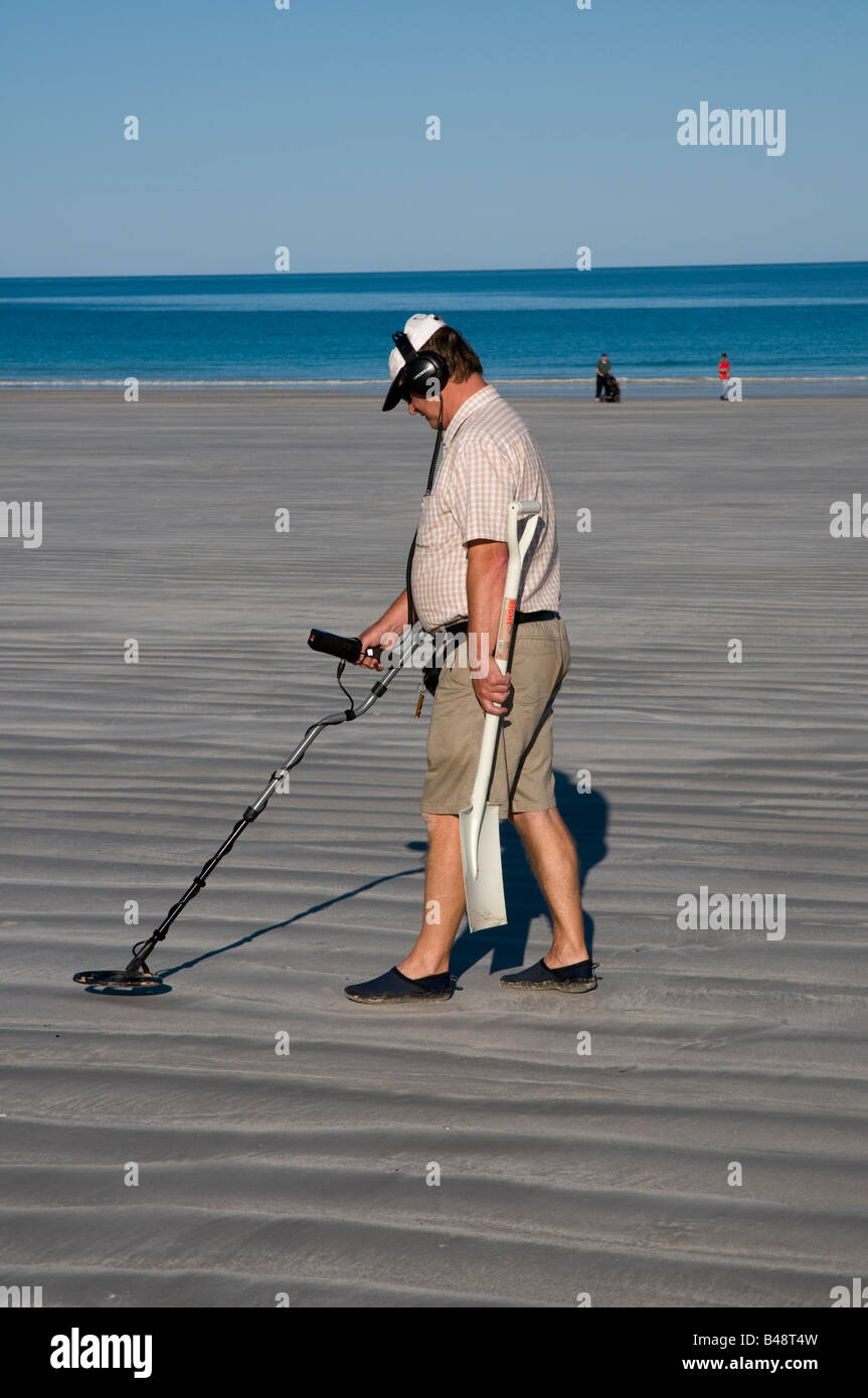 Man with metal detector and spade looking for lost objects on Cable