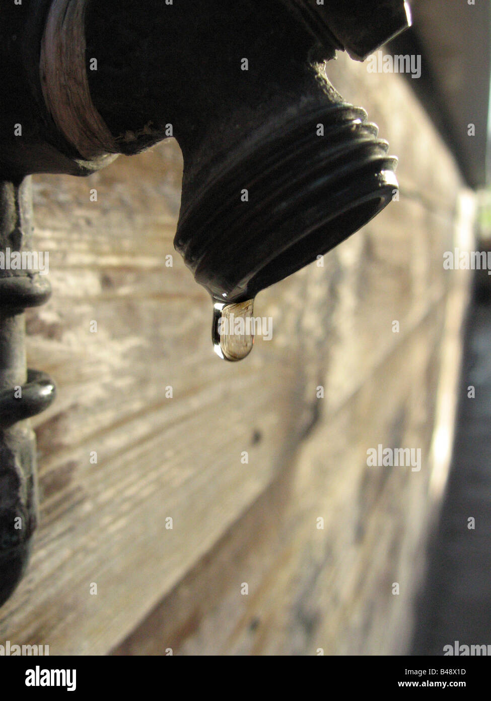 A dripping and neglected tap illustrates the importance of maintenance for water conservation. Stock Photo