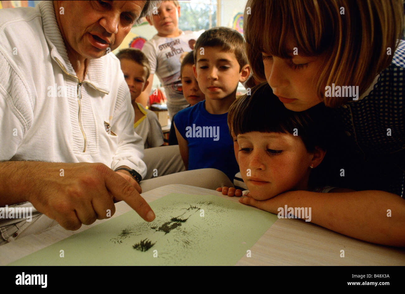 Primary school teacher explaining the priciples of magnetism to his class Stock Photo