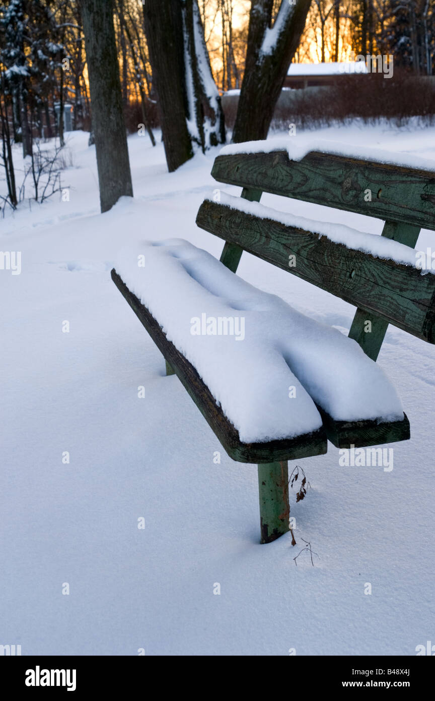 Snow covered bench in a park on a cold winter evening Stock Photo - Alamy