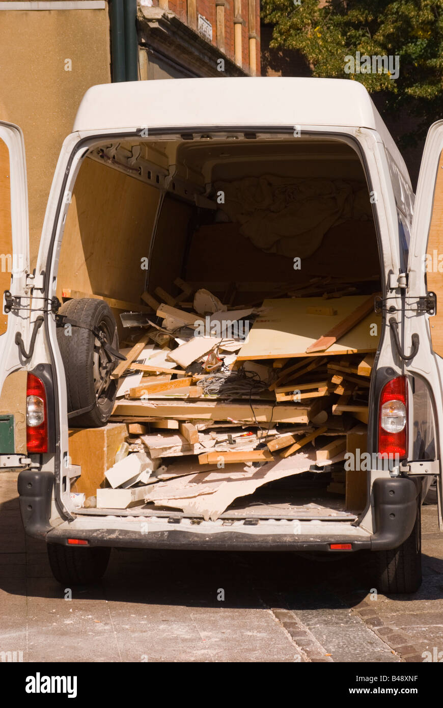 View of the back of a work van filled with rubbish from a building job after clearing up. Stock Photo