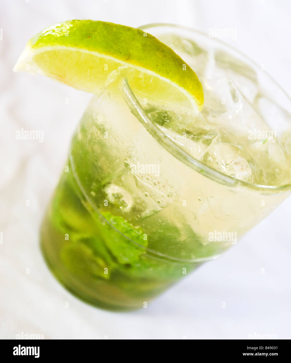 Alcoholic cocktail drink called a Mojito, with a lemon decoration in a