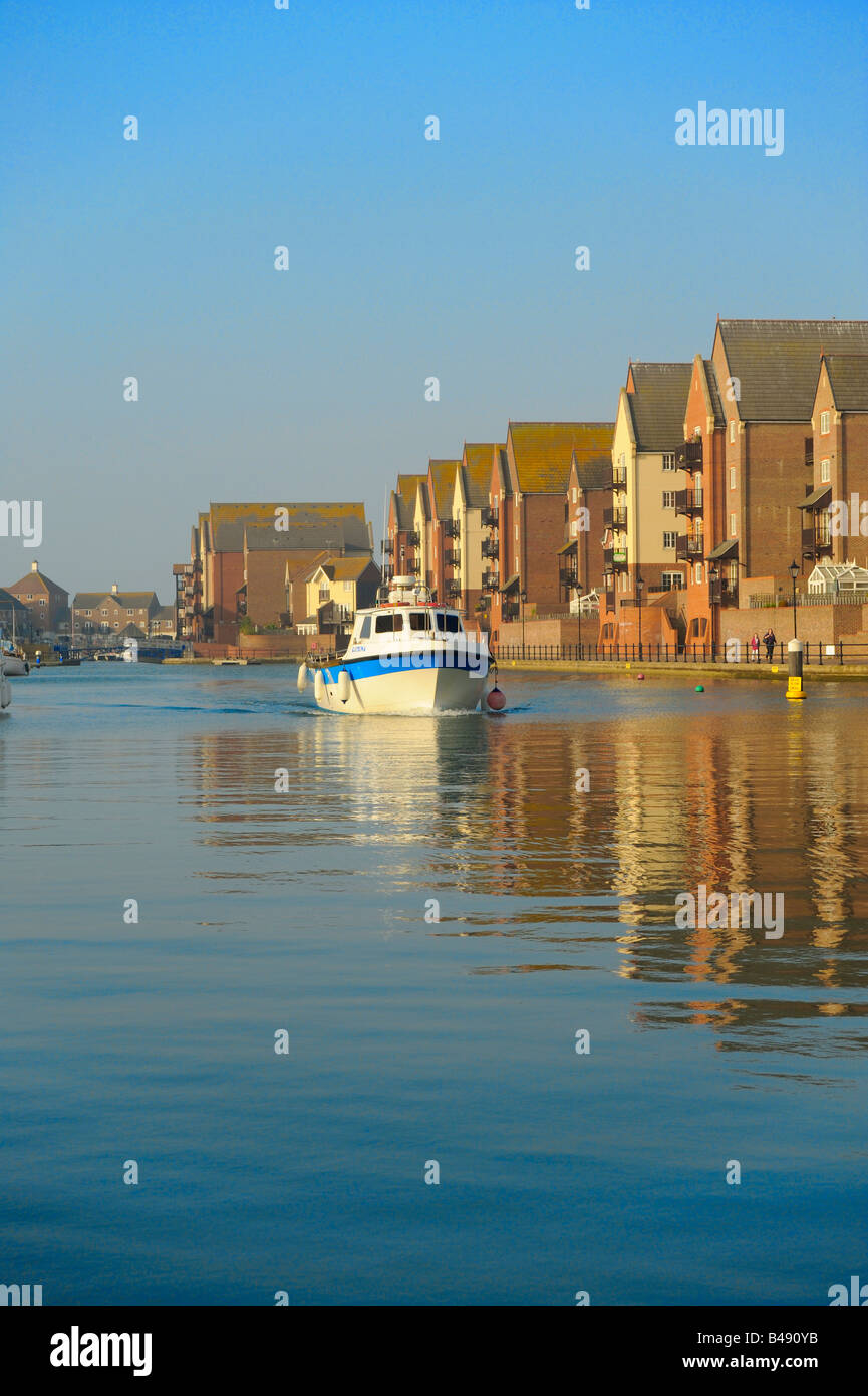 Fishing boat cruising along the quay-side in a harbour Stock Photo - Alamy