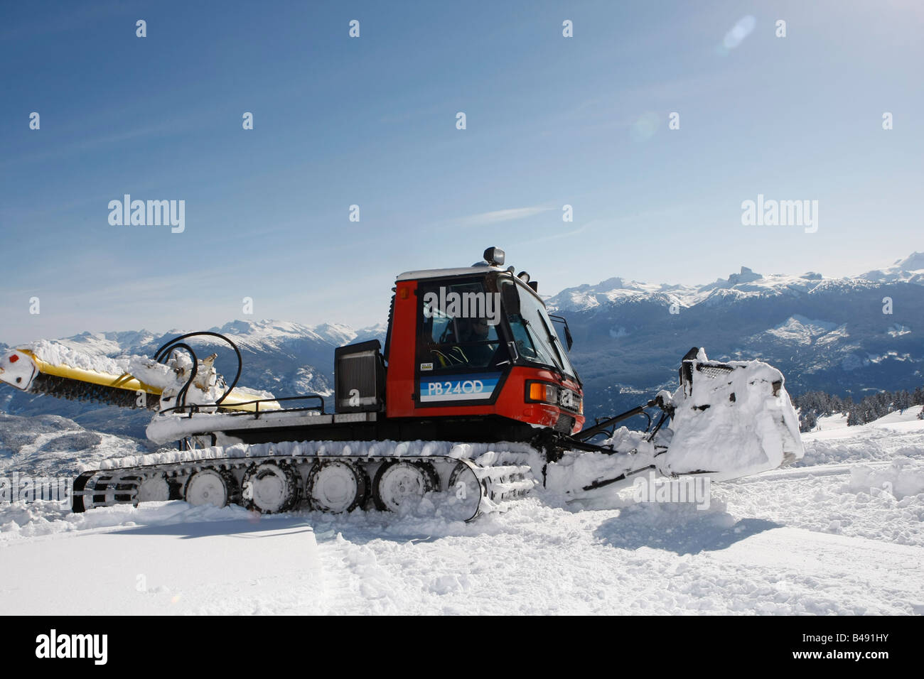 snow cat plowing snow to build a snowboard jump Stock Photo - Alamy