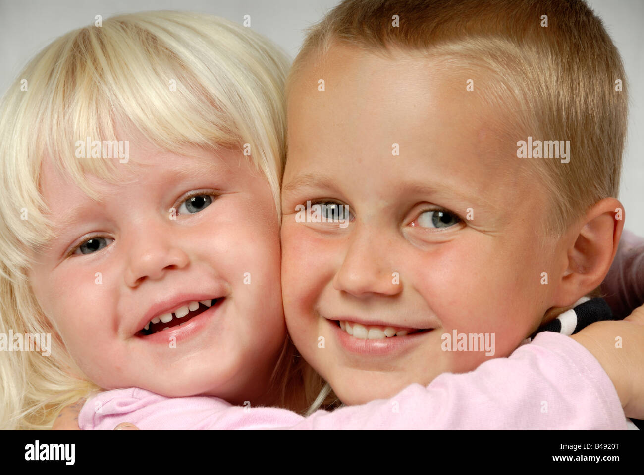 Stock photo of a brother and sister 3 years old and nine years old hugging each other Stock Photo