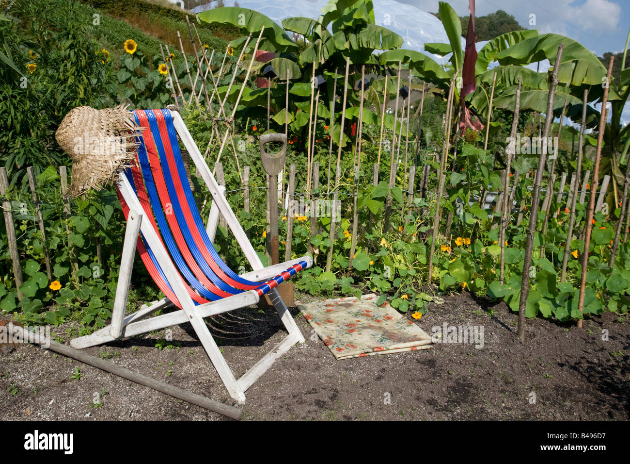Empty striped deckchair in vegetable garden Eden Project Bodelva St Austell Cornwall UK Stock Photo