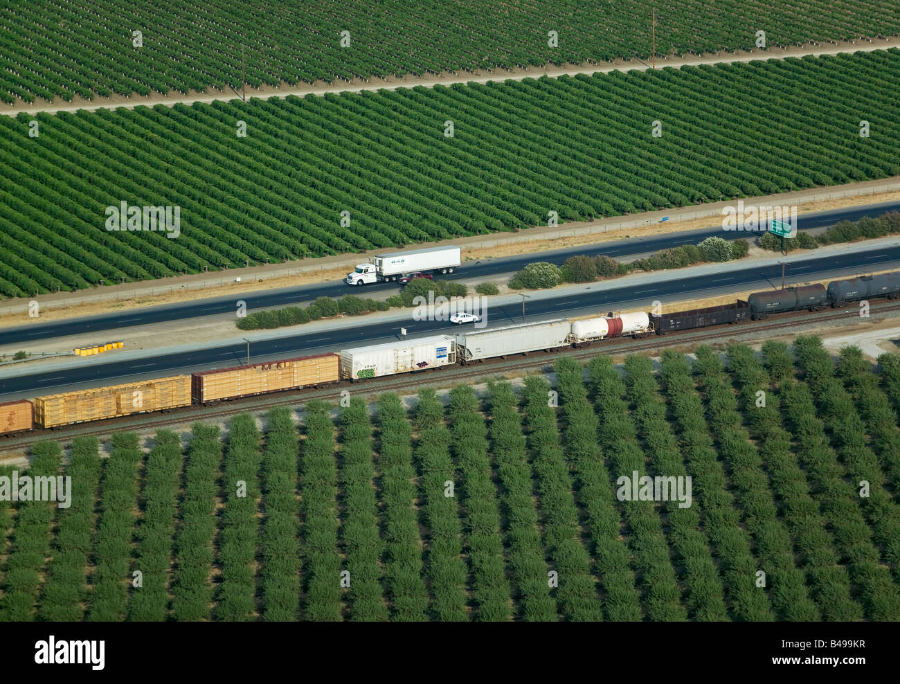 aerial above orchards railroad and highway 99 north of Delano California central valley Stock Photo