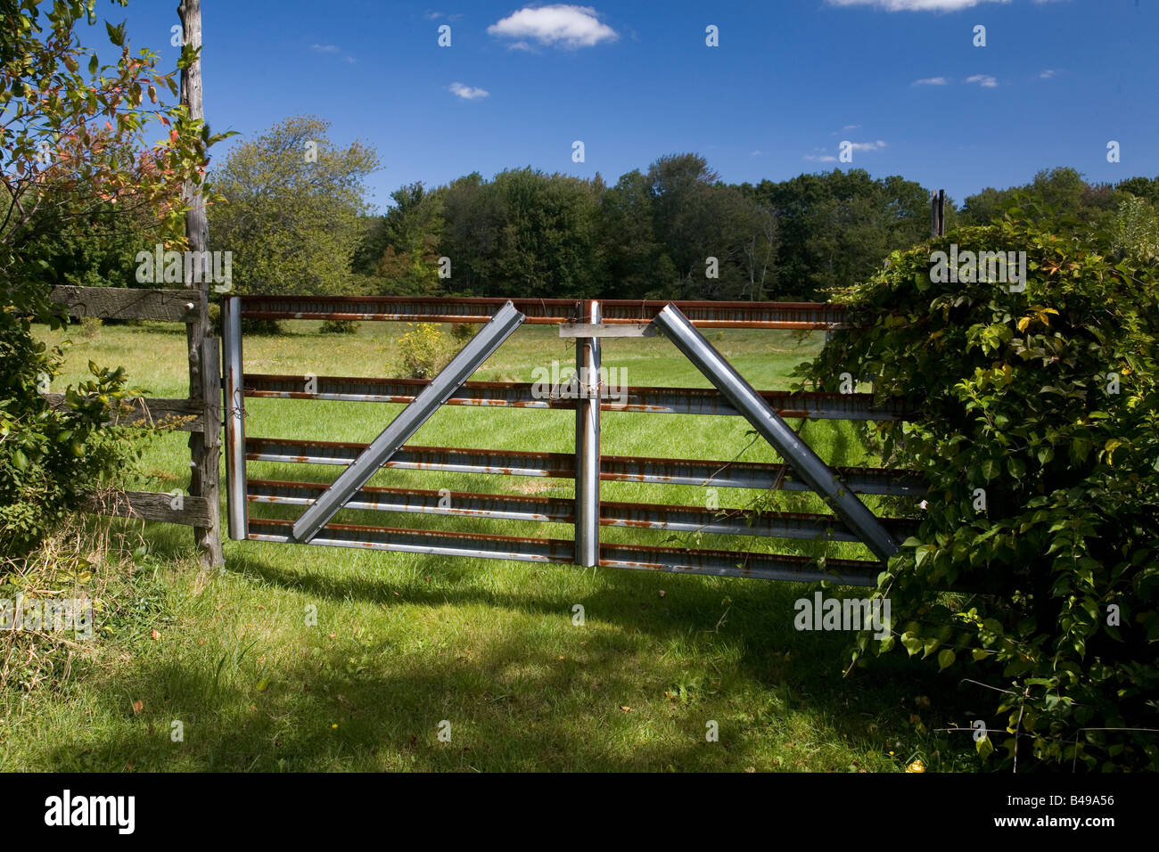 Photograph of a metal fence in front of a field Stock Photo - Alamy