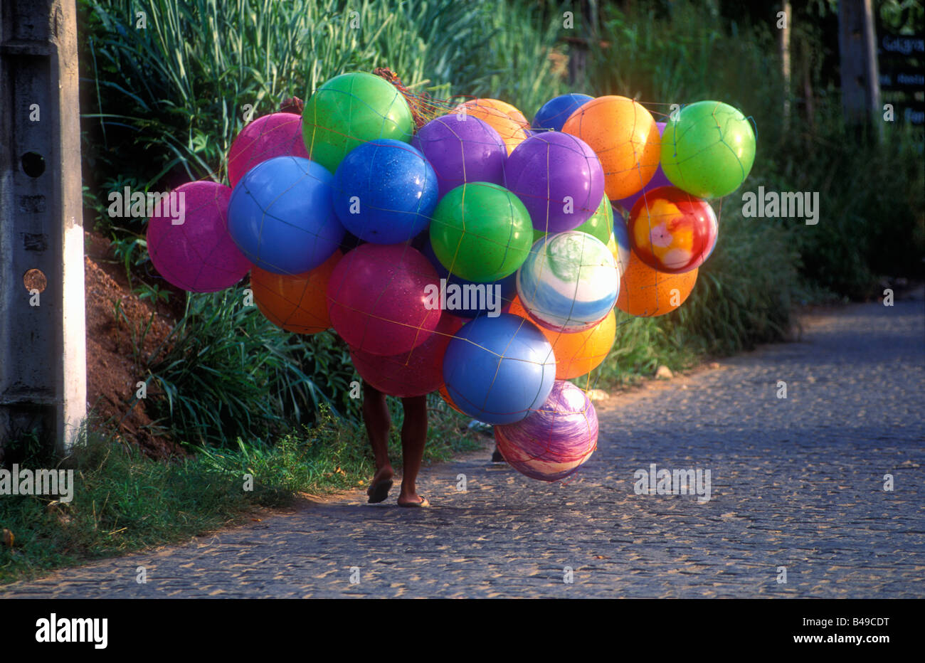 man carrying big and colorfull balloons Stock Photo