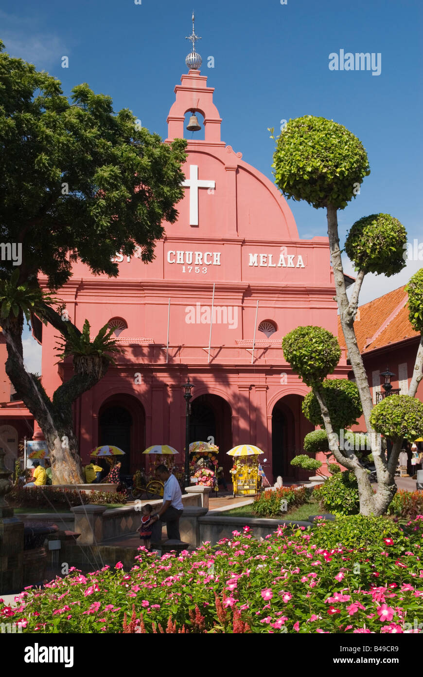 Trishaws parked under the red Christ Church in the popular tourist centre of Dutch Square, Malacca, Malaysia Stock Photo