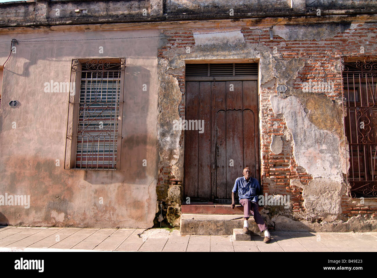 Old Man sitting before a lod house Camaguey Cuba Stock Photo