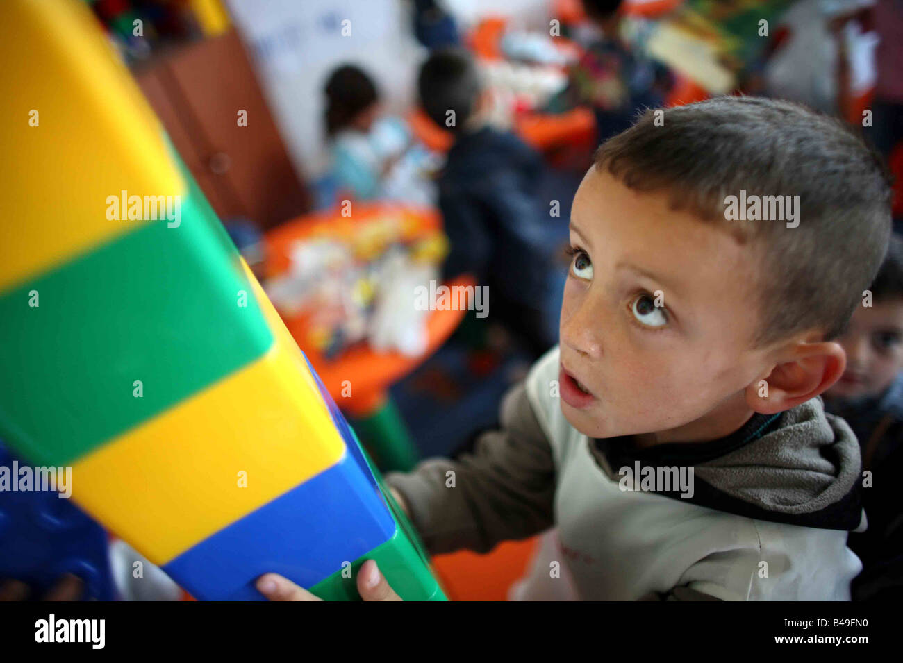 Roma gypsy boy playing with building blocks in a preschool in Albania Stock Photo