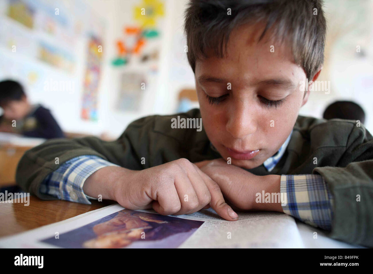 Roma gypsy boy reads about Lenin in class in school in Korca, Albania Stock Photo
