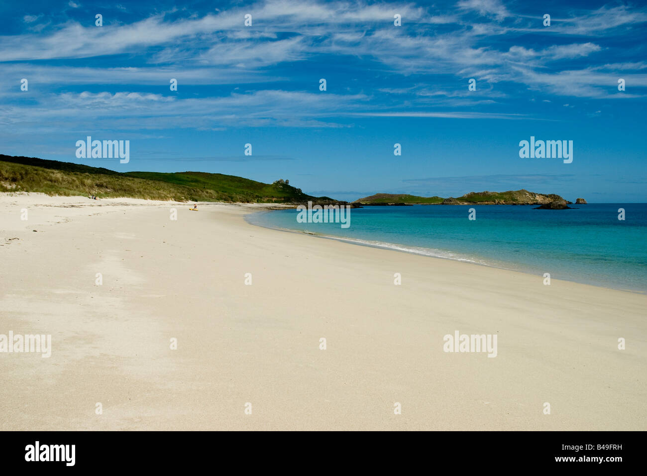 An almost deserted beach, clear skies and crystal clear water typify the beauty of Great Bay, St Martin's, Isles of Scilly Stock Photo