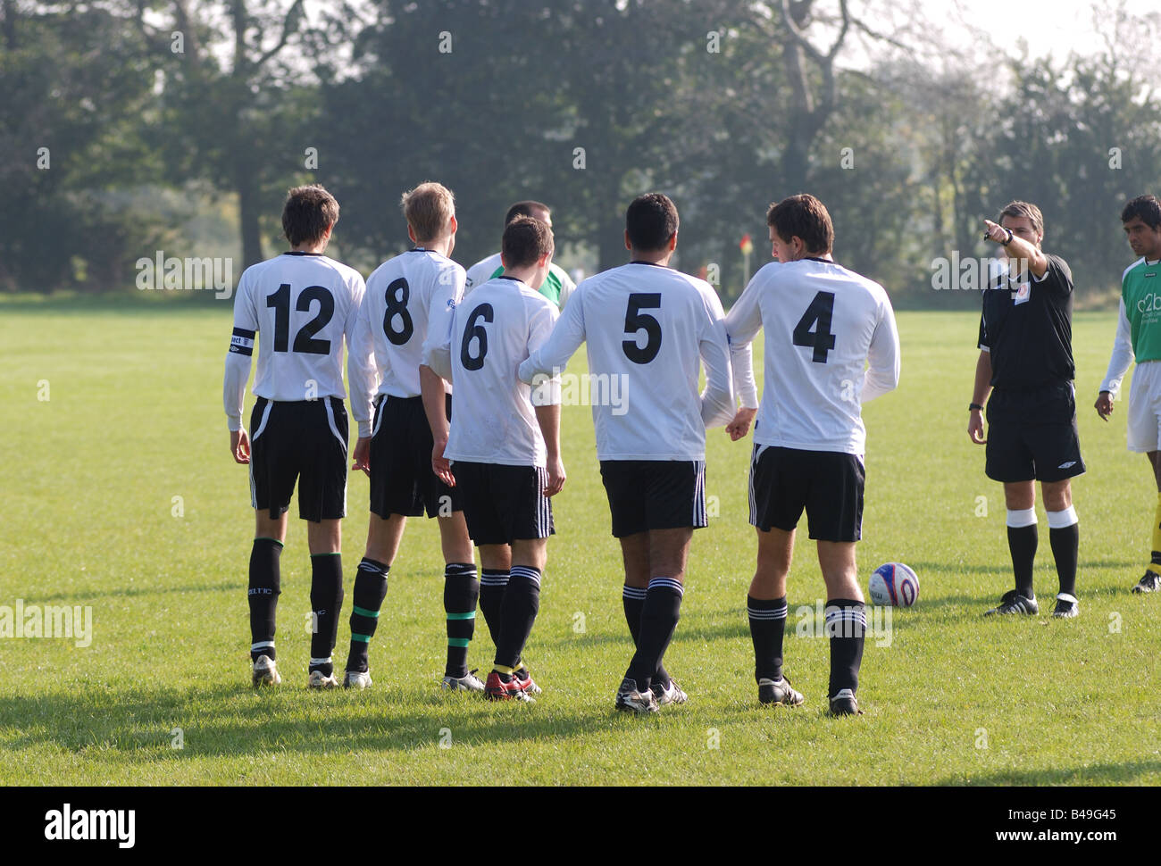 Referee making football players stand back for free kick in Sunday League game UK Stock Photo