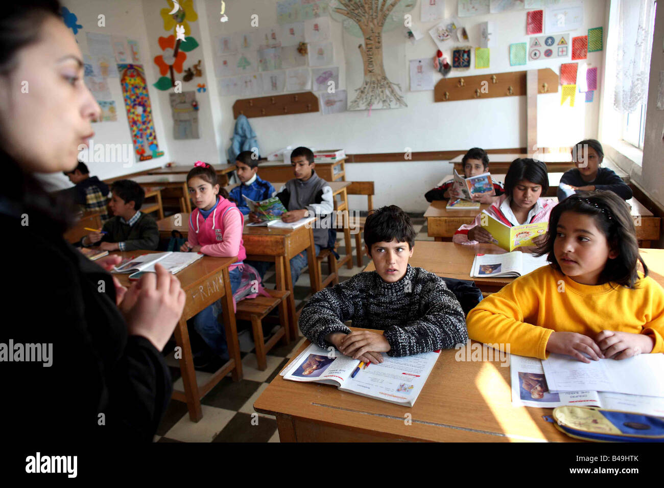 Primary school Roma gypsy children study with their teacher in a class