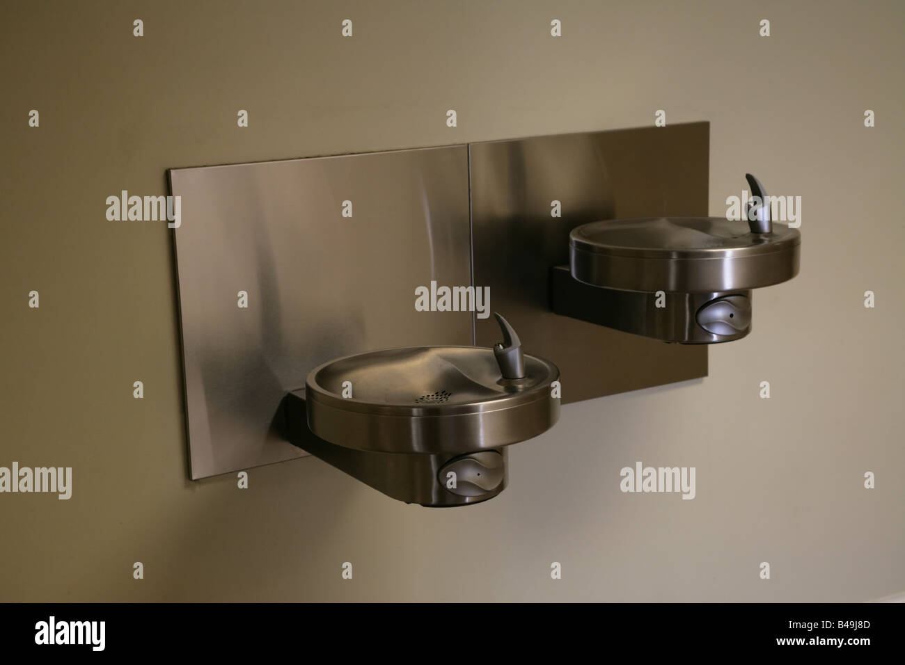 A wallmounted, stainless steel drinking fountain with two levels, a