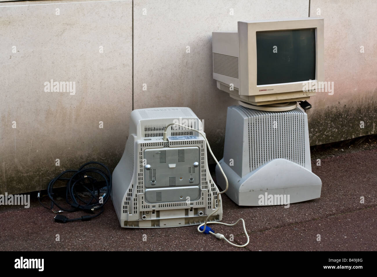 Three old obsolete computer screen monitors discarded as junk on the