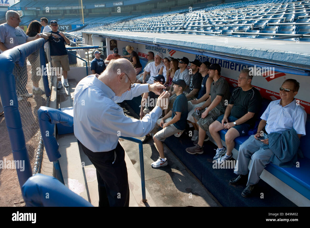 Fans on the Yankee stadium tour sit in the dugout and take snapshots of one another Stock Photo