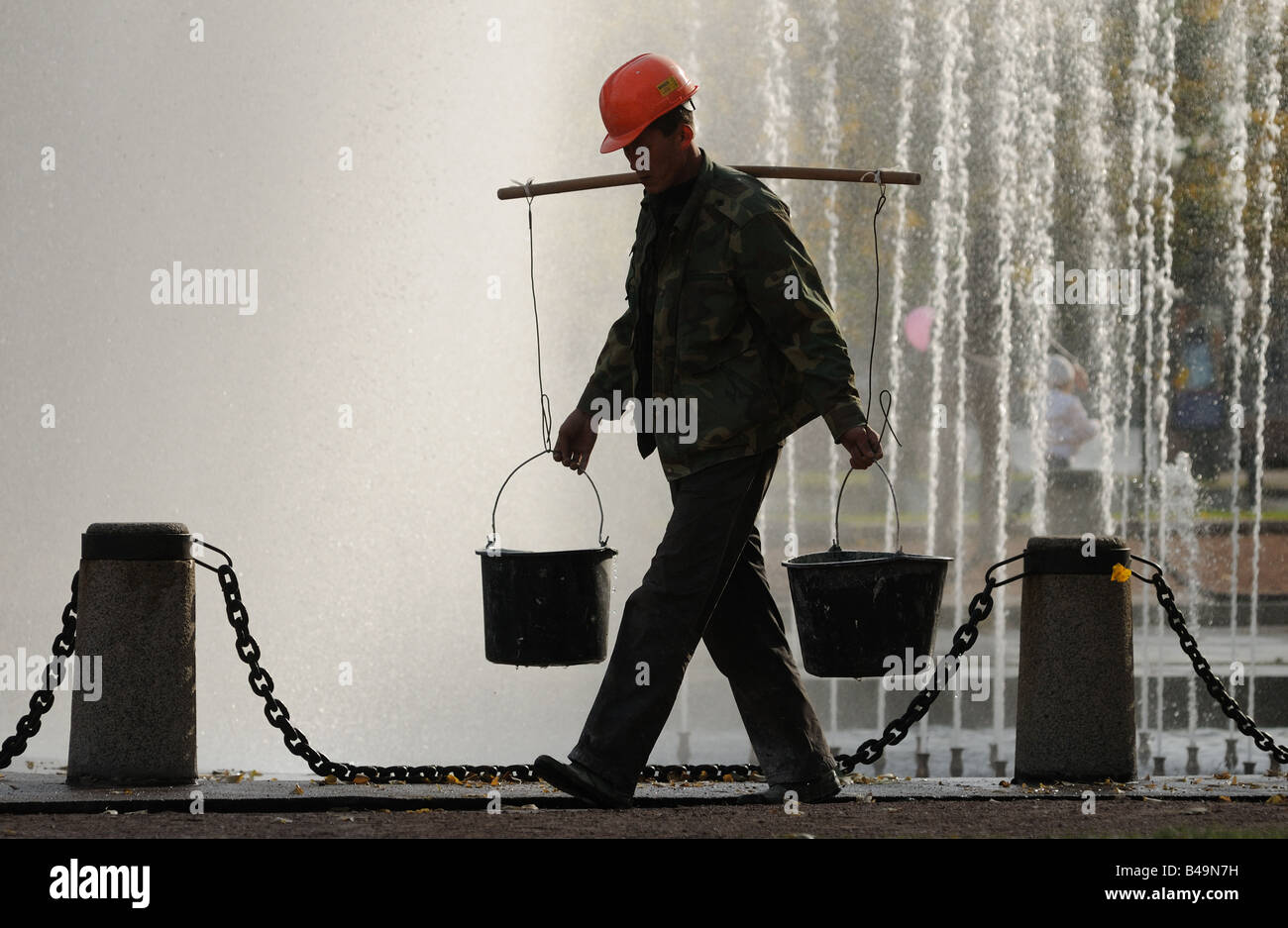 Worker gaining water from city fountain in the buckets Stock Photo Alamy
