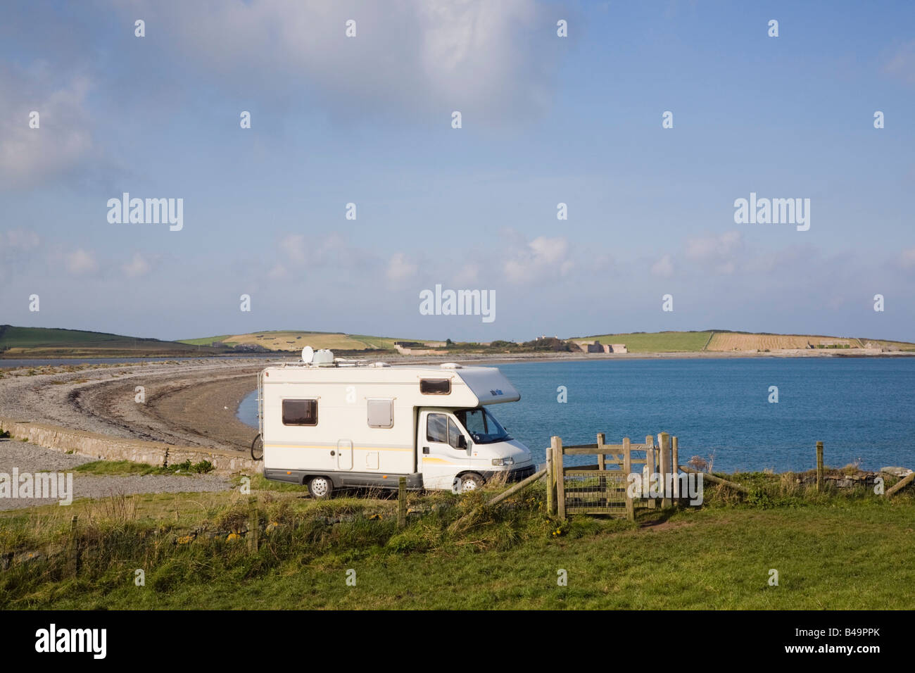 Motorhome parked at seaside by beach in rural beauty spot on coast. Cemlyn Bay Anglesey Wales UK Britain Stock Photo