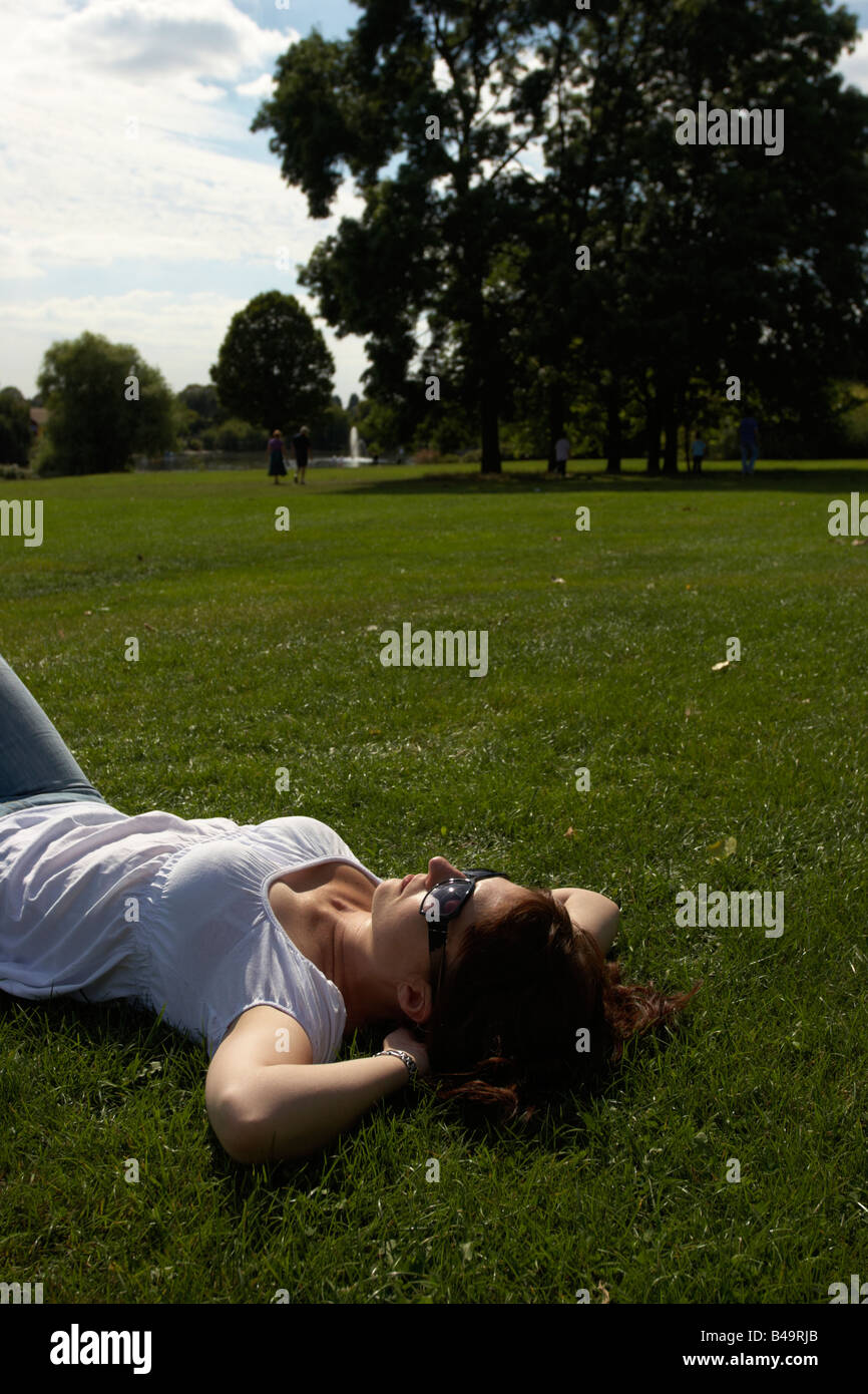 Woman sunbathing in park Stock Photo