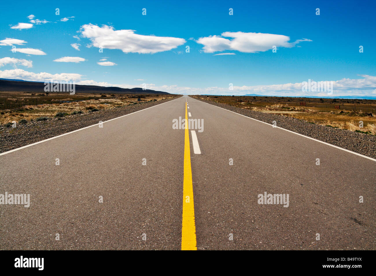 A long straight empty road stretching into the distance Two white ...