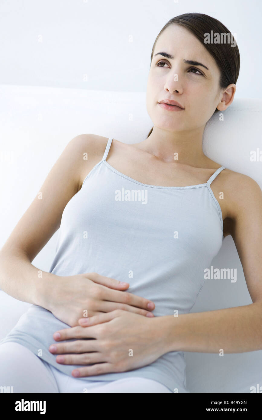 Woman reclining, holding stomach Stock Photo Alamy