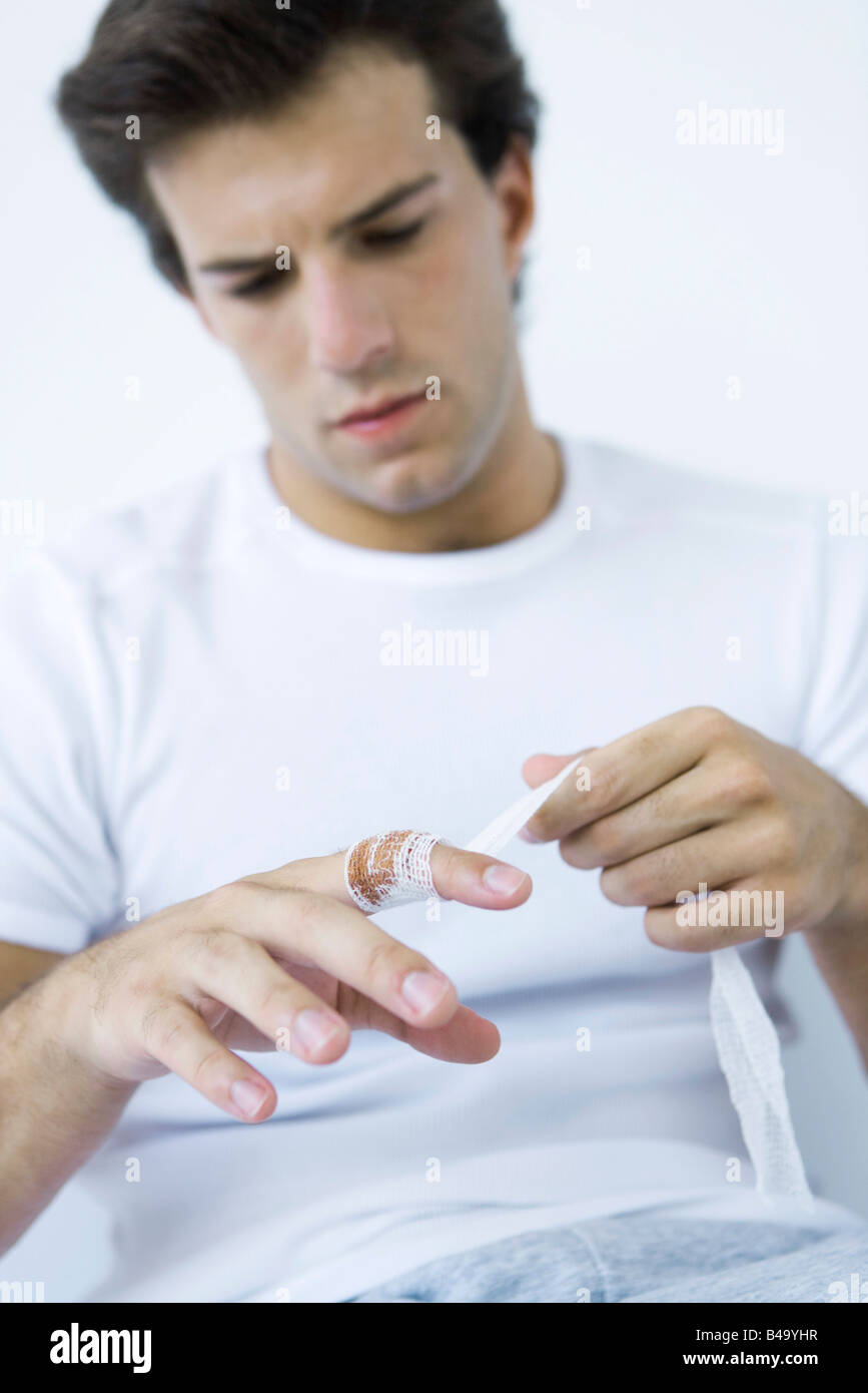 Man wrapping gauze around injured finger Stock Photo Alamy