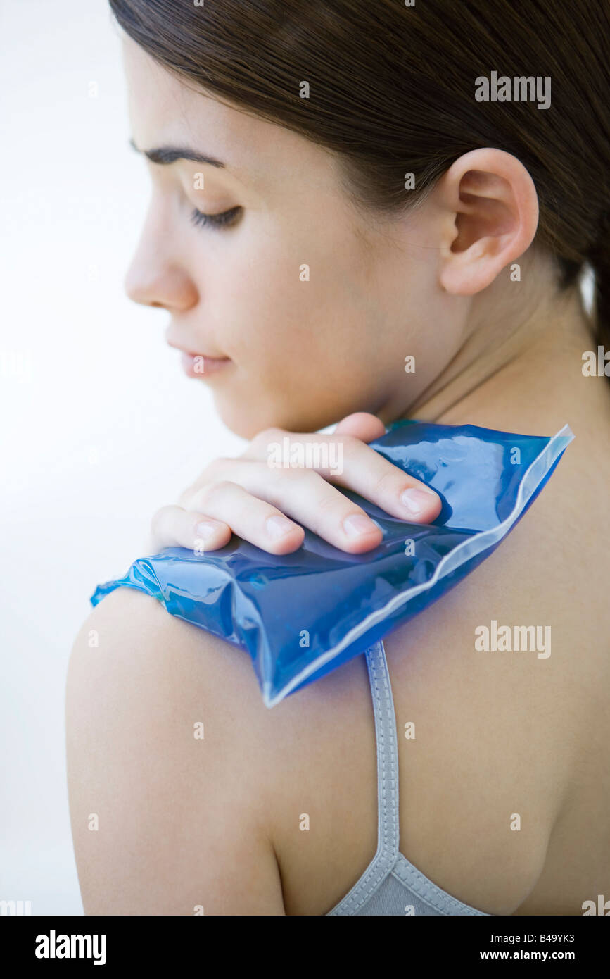 Woman placing cold compress on shoulder, close-up Stock Photo