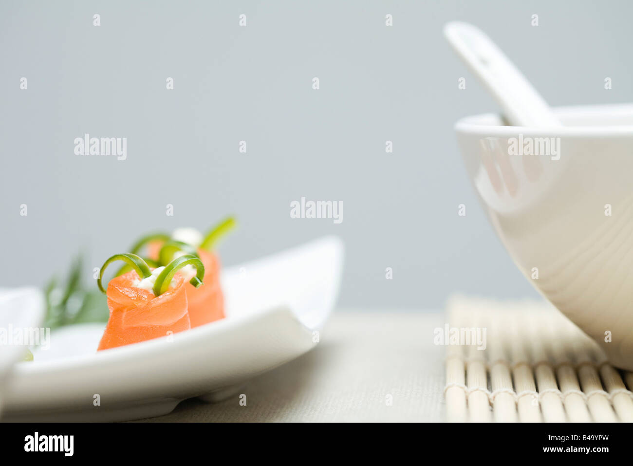 Cropped view of salmon maki sushi and bowl of soup Stock Photo