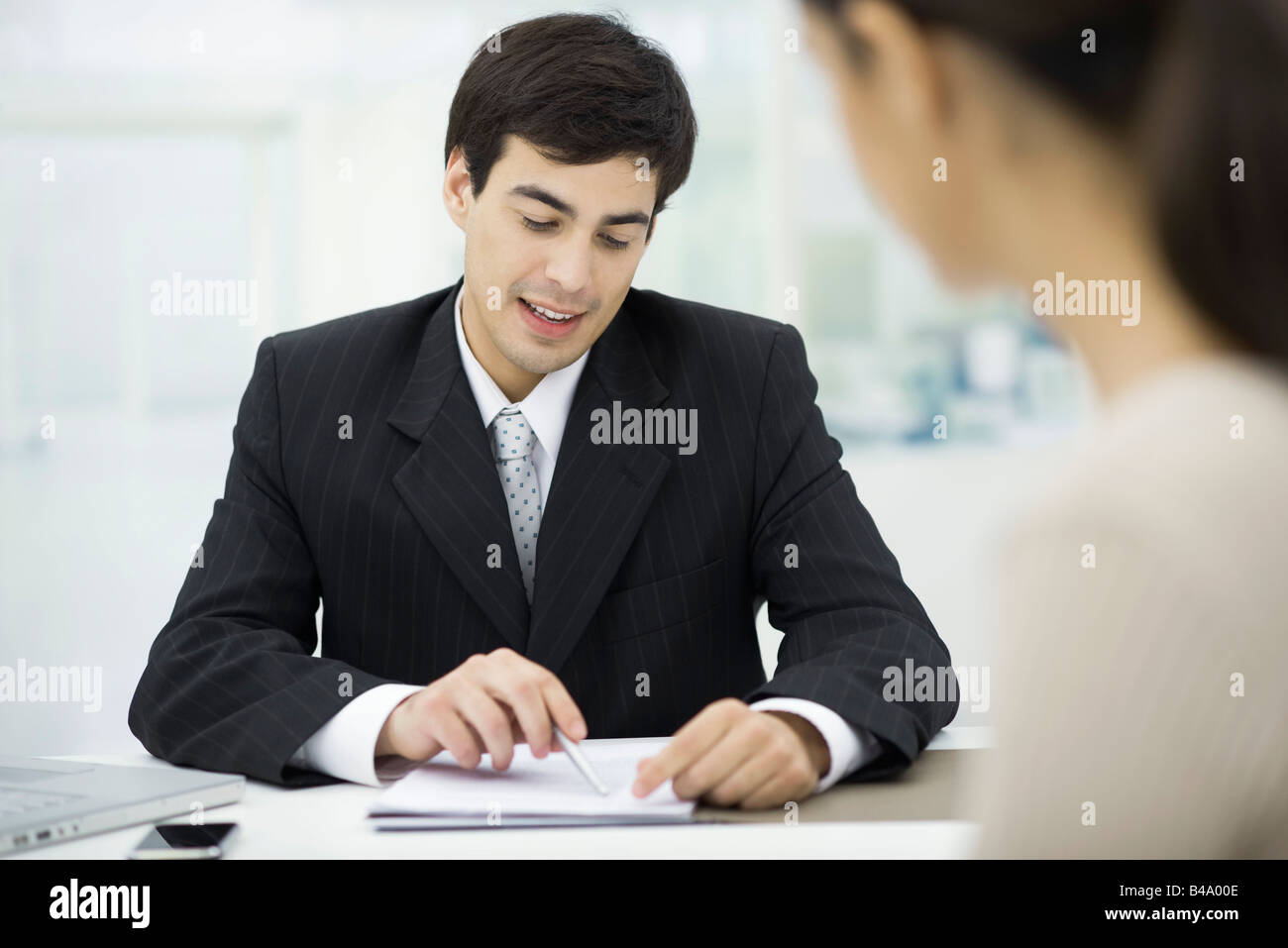 Businessman explaining document to client Stock Photo