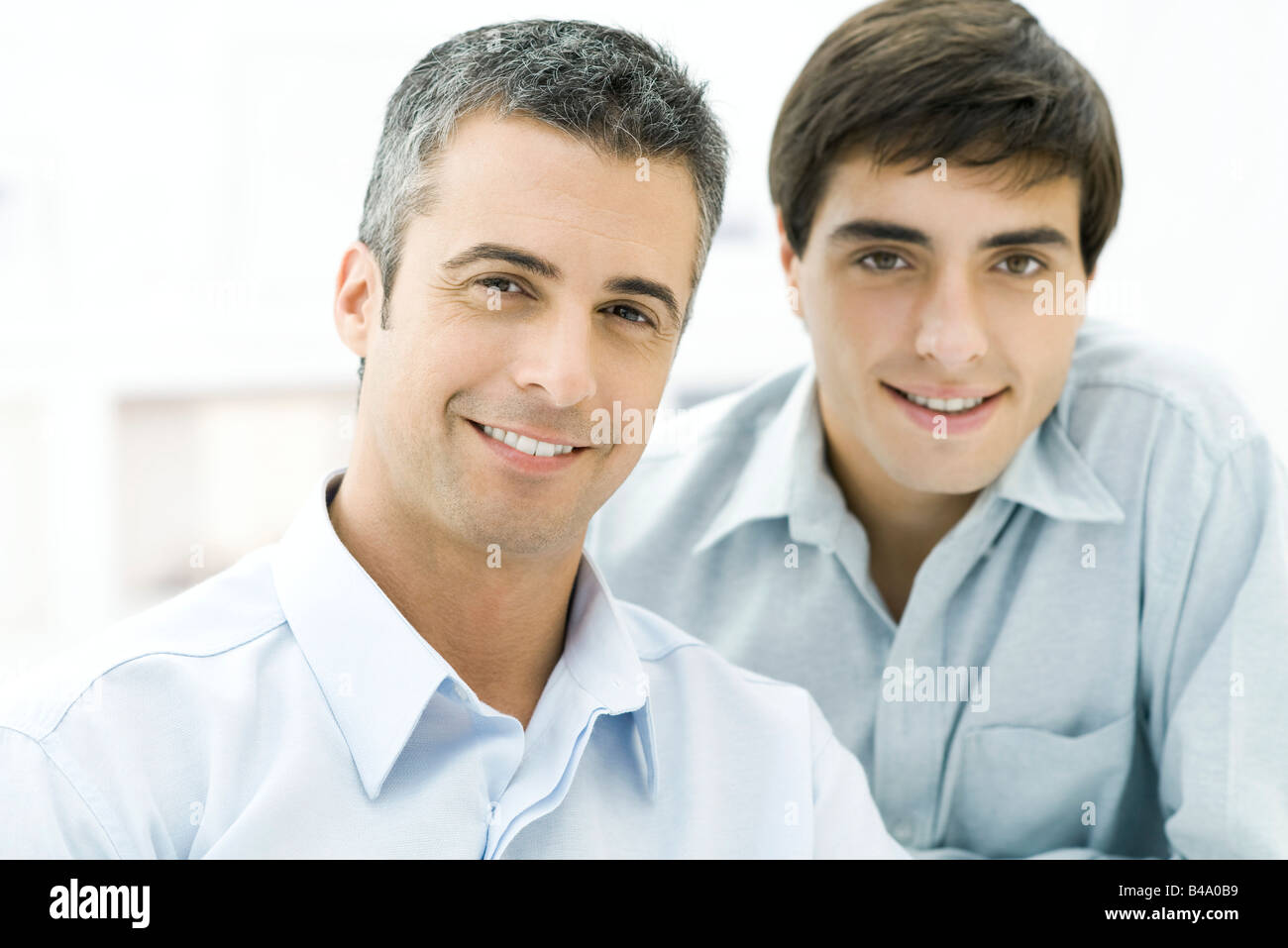 Father and adult son smiling at camera, portrait Stock Photo - Alamy