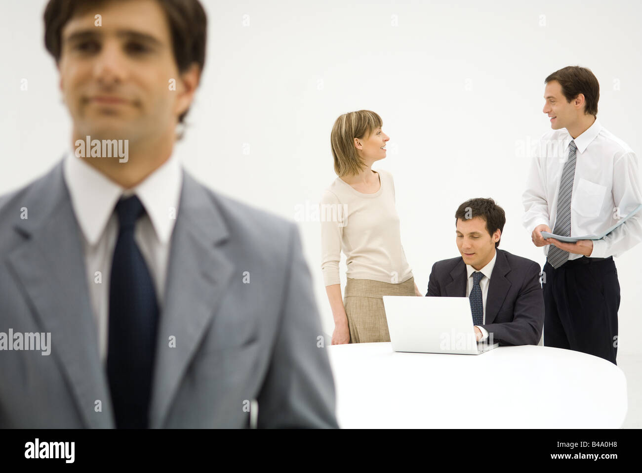 Business associates talking, man in foreground Stock Photo