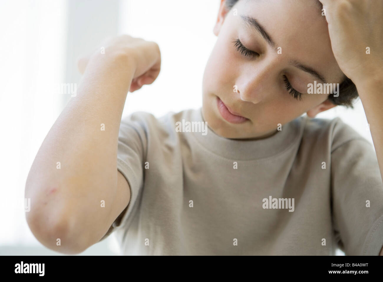 Boy holding up elbow, eyes closed Stock Photo Alamy