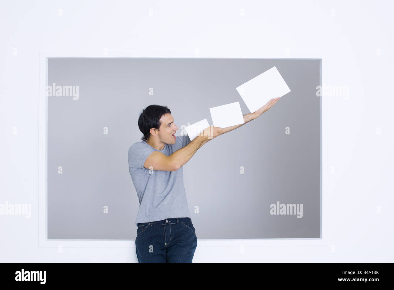 Man holding up blank papers, shouting Stock Photo