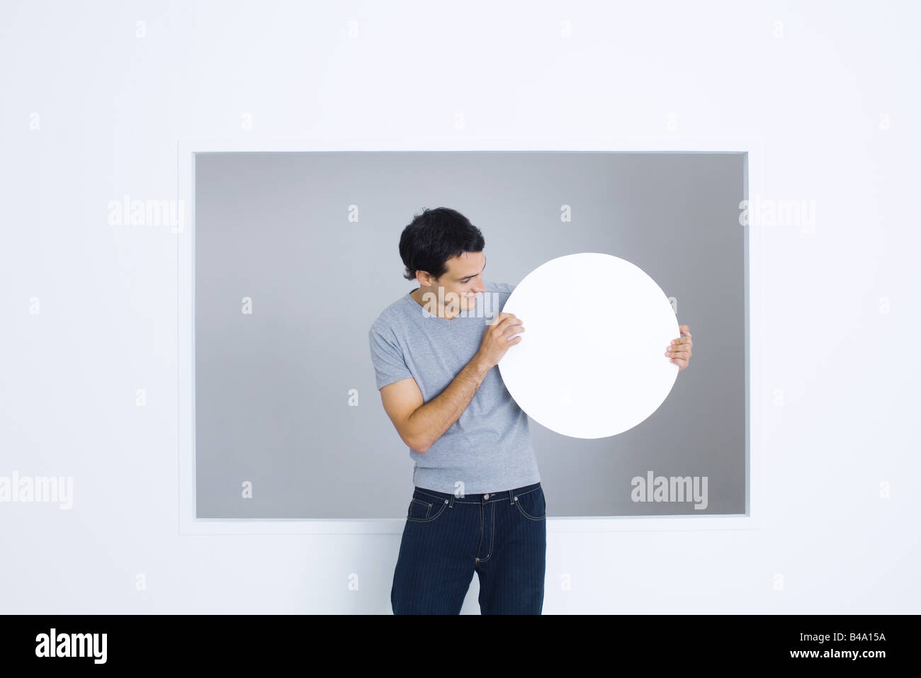 Man looking blank circular sign in hands, smiling Stock Photo